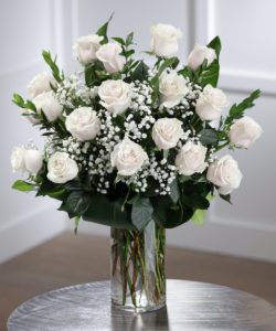 The finest white luxury Ecuadorian roses, carefully hand-picked and artfully arranged with lush foliage and perfecta babies breath in a chic glass vase. 