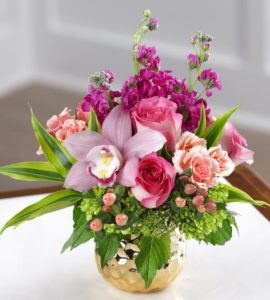 pink roses and lavender orchid and greenery in copper vase