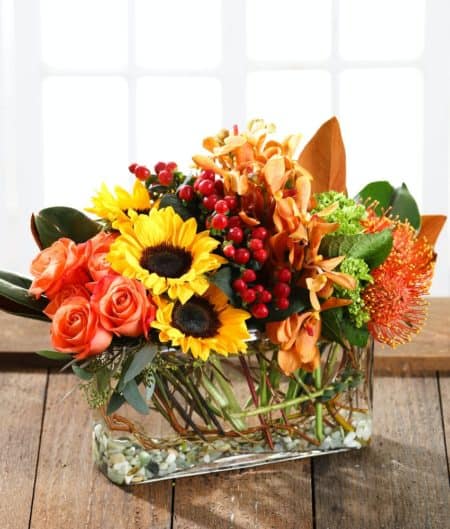 A sophisticated, contemporary floral design, artfully arranged in a modern glass featuring autumn roses, pincushion protea, sunflowers, southern green hydrangea, exotic orchids, hypericum berries and fall foliage & accents. Every Carithers arrangement is custom designed and hand-delivered just for you. Available for delivery throughout metro Atlanta